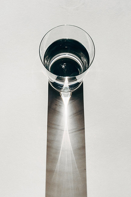 Ein Wasserglas, das einen langen Schatten wirft