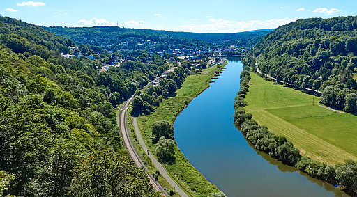 Luftaufnahme der Weser, umgeben von grünen Feldern und Wäldern